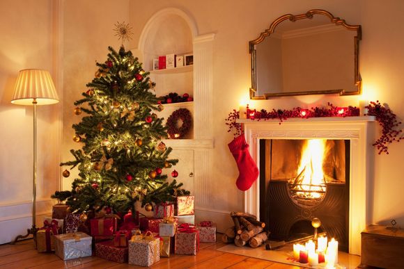 Geschmückter Weihnachtsbaum neben Kamin.